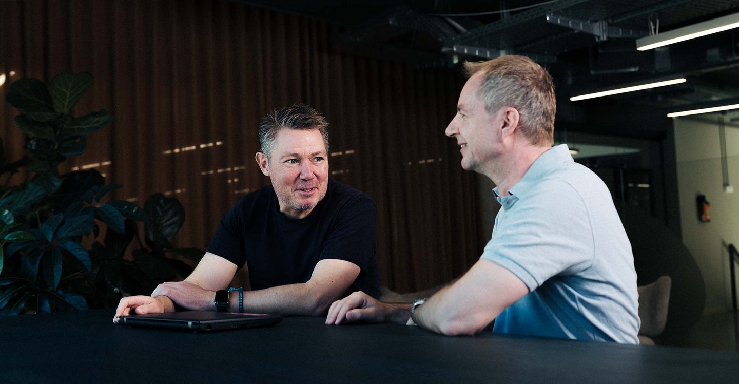 coworkers-smilling-with-ipad-on-table