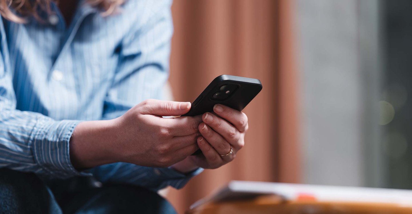 woman-holding-phone-while-sitting