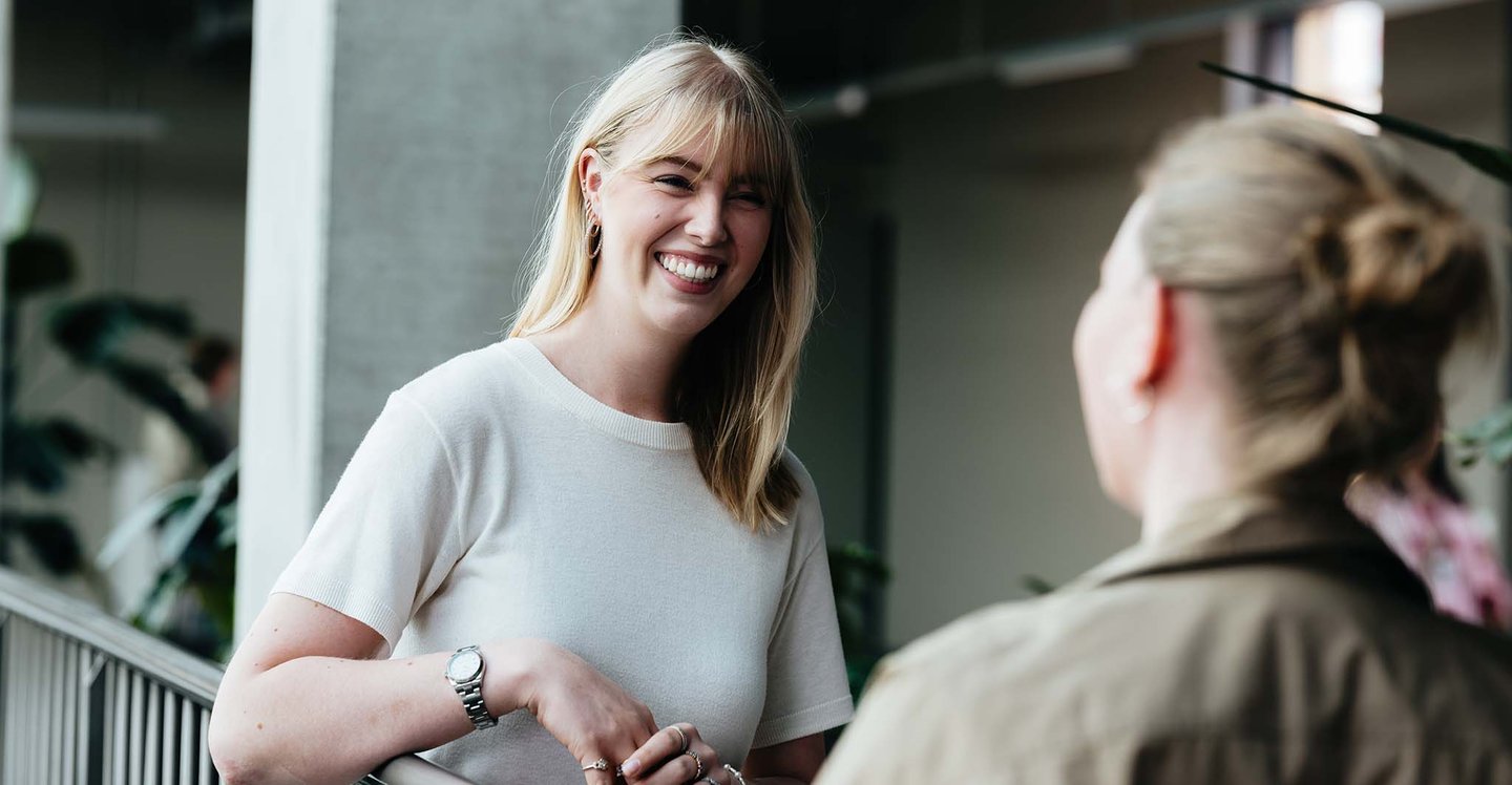 woman-smilling-while-talking-with-coworker