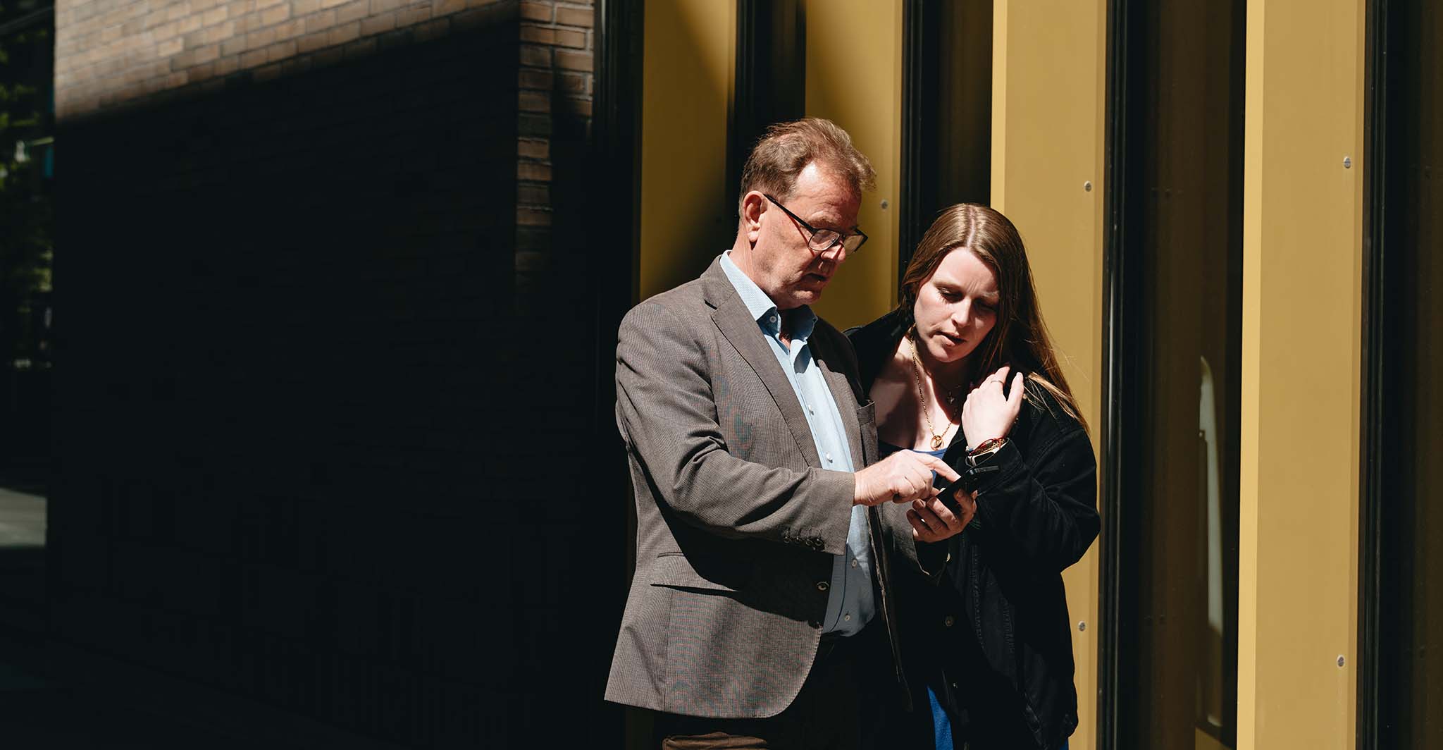 coworkers-outside-looking-at-phone-close-up