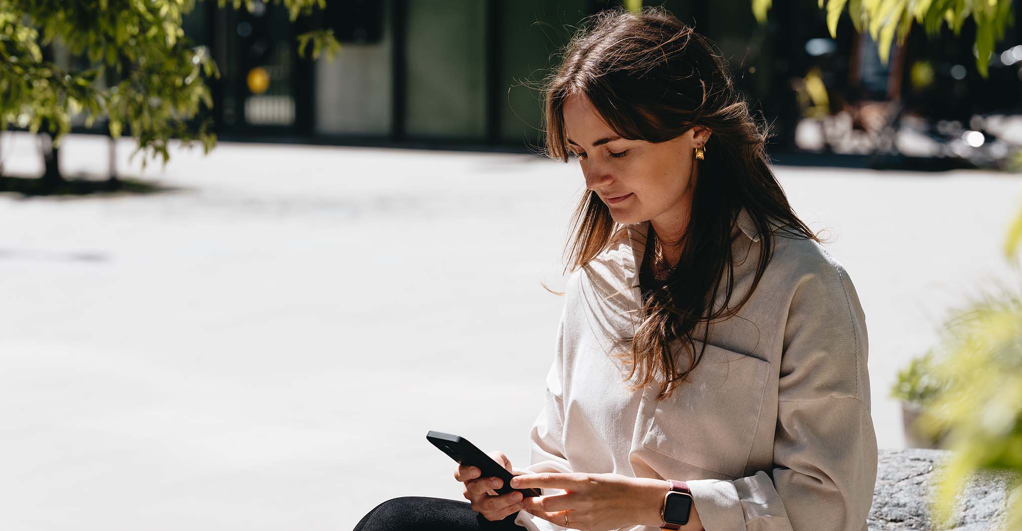 woman-with-smartwatch-looking-at-her-phone